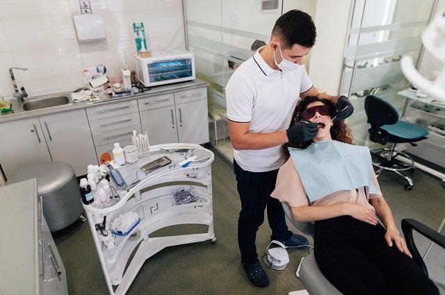 orthodontist-performing-whitening-patient
